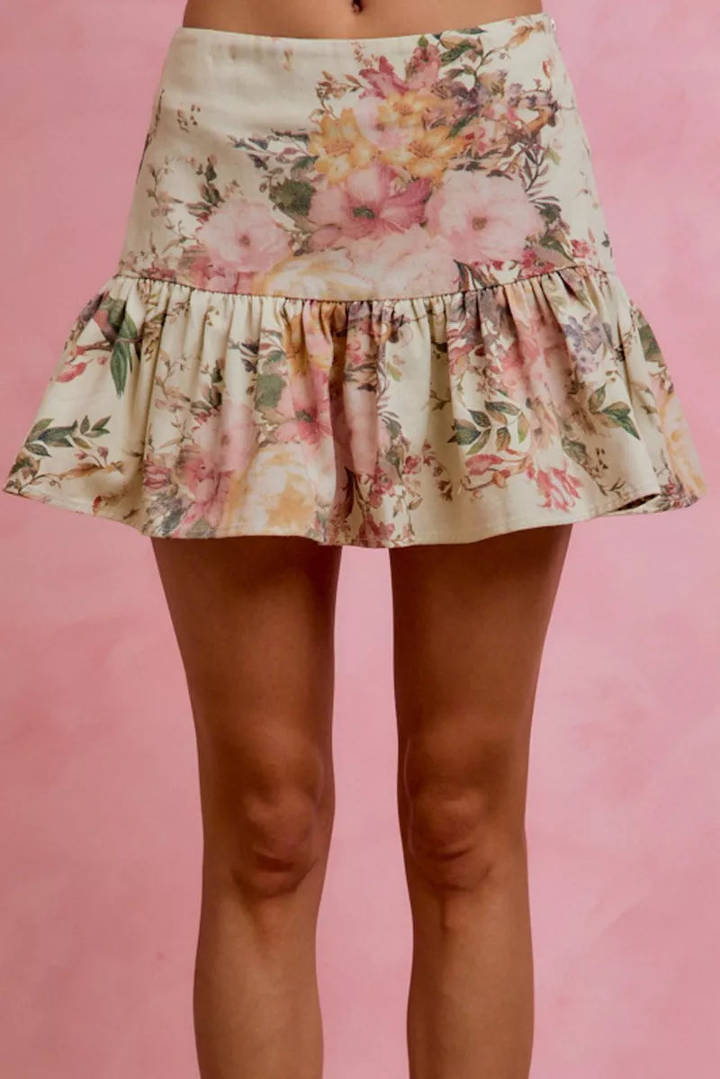 Floral skirt worn by a person on a pink background
