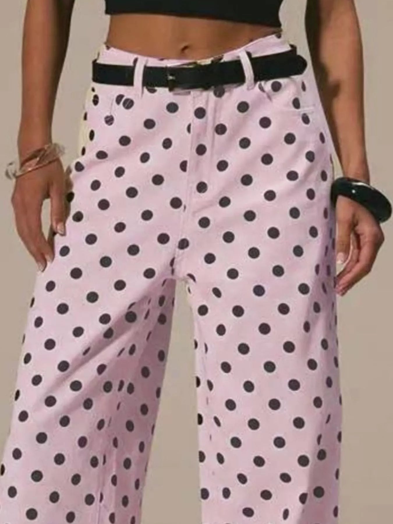 Pink polka dot pants worn by a person on a plain background