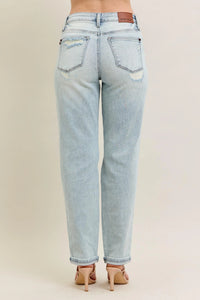 Light blue jeans worn by a person on a beige background