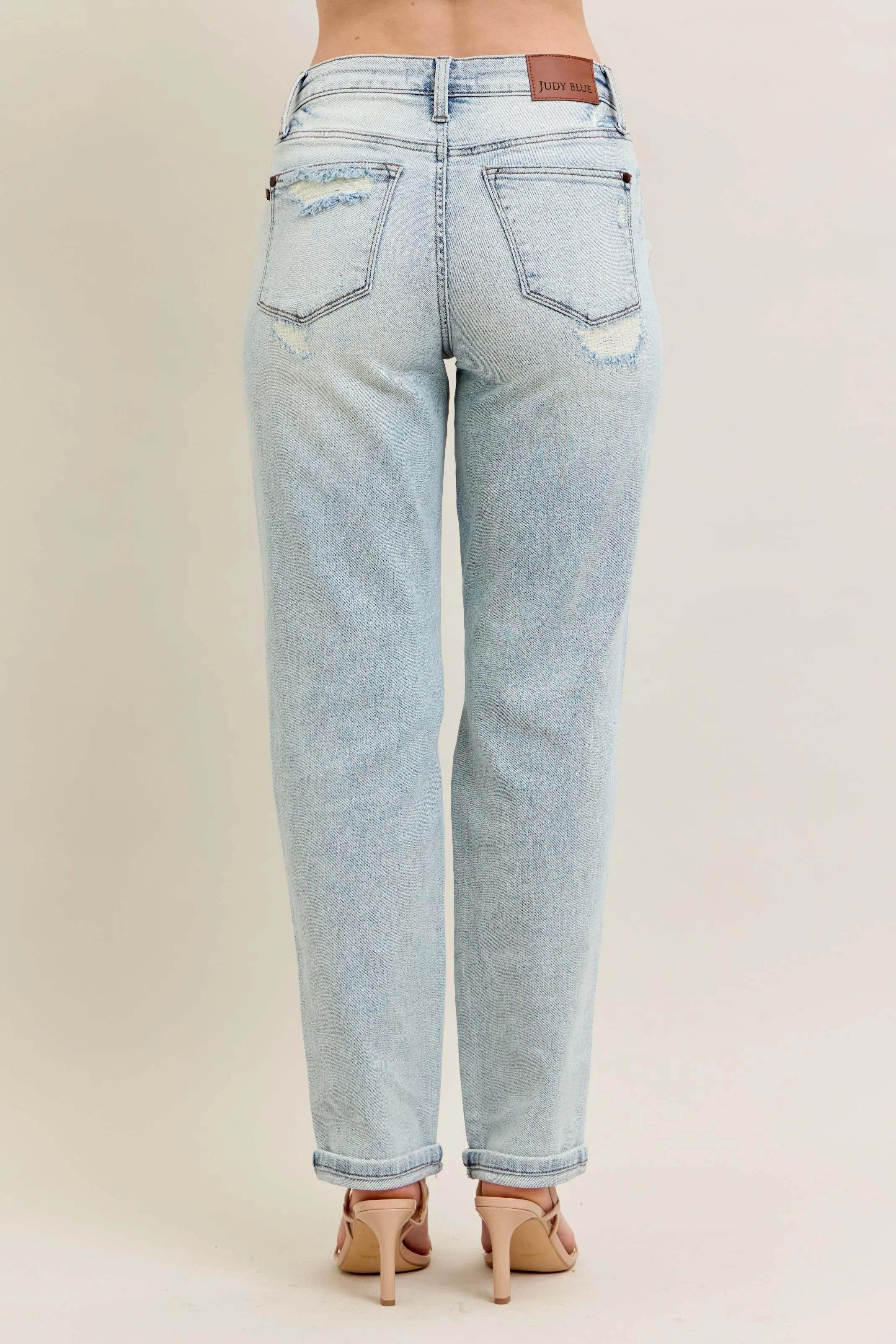 Light blue jeans worn by a person on a beige background