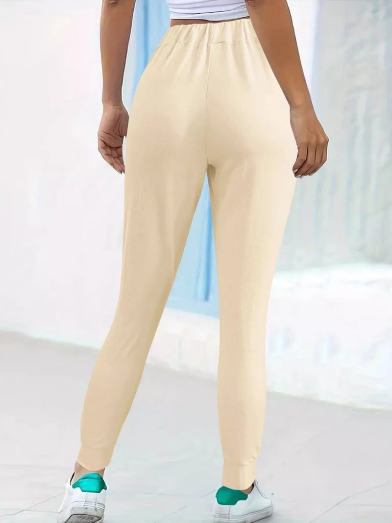 Beige sweatpants worn by a person on a light background