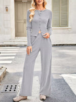 Woman wearing a gray outfit standing on a street.