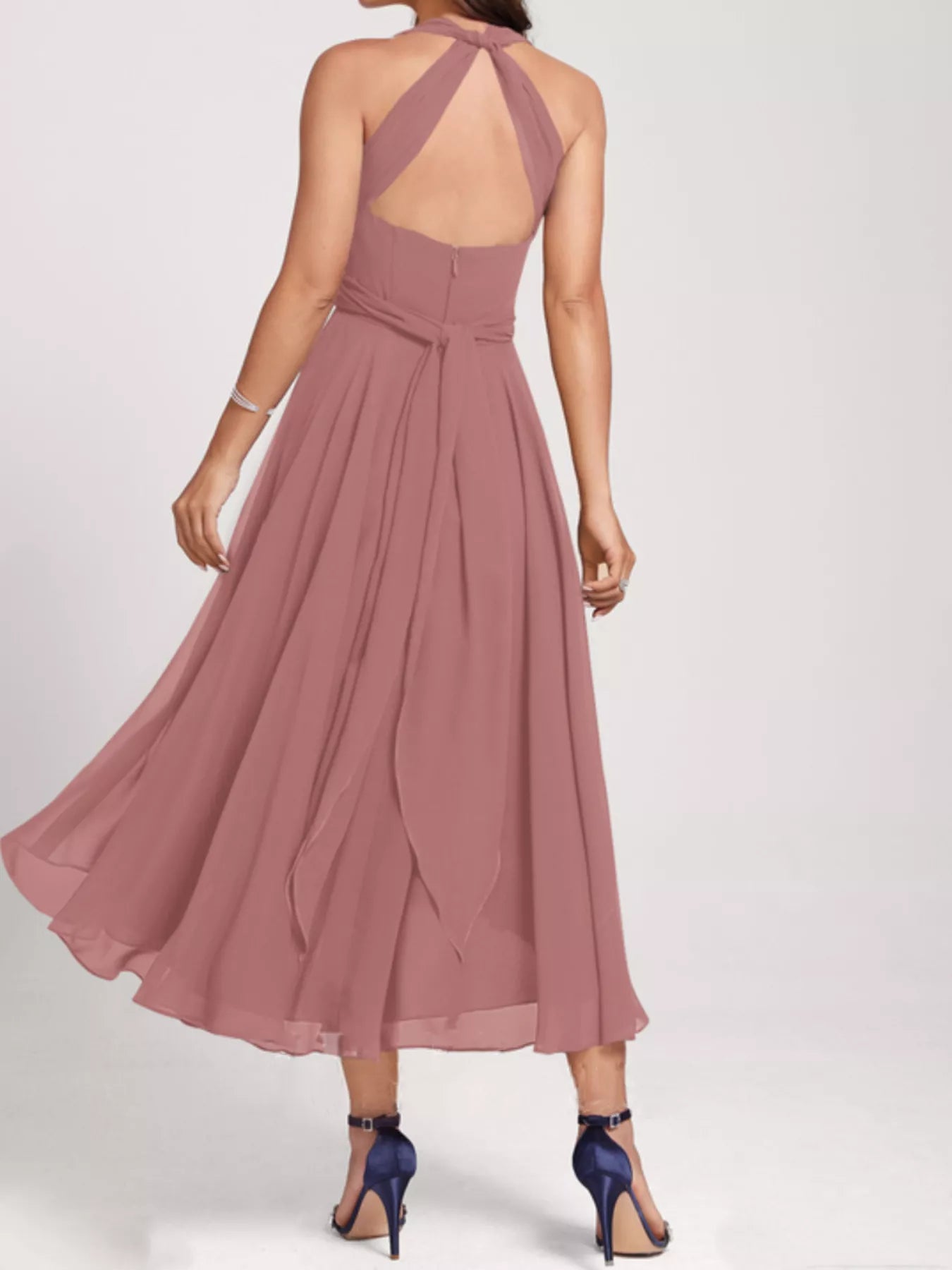 Mauve halter neck dress with a flowing skirt on a white background