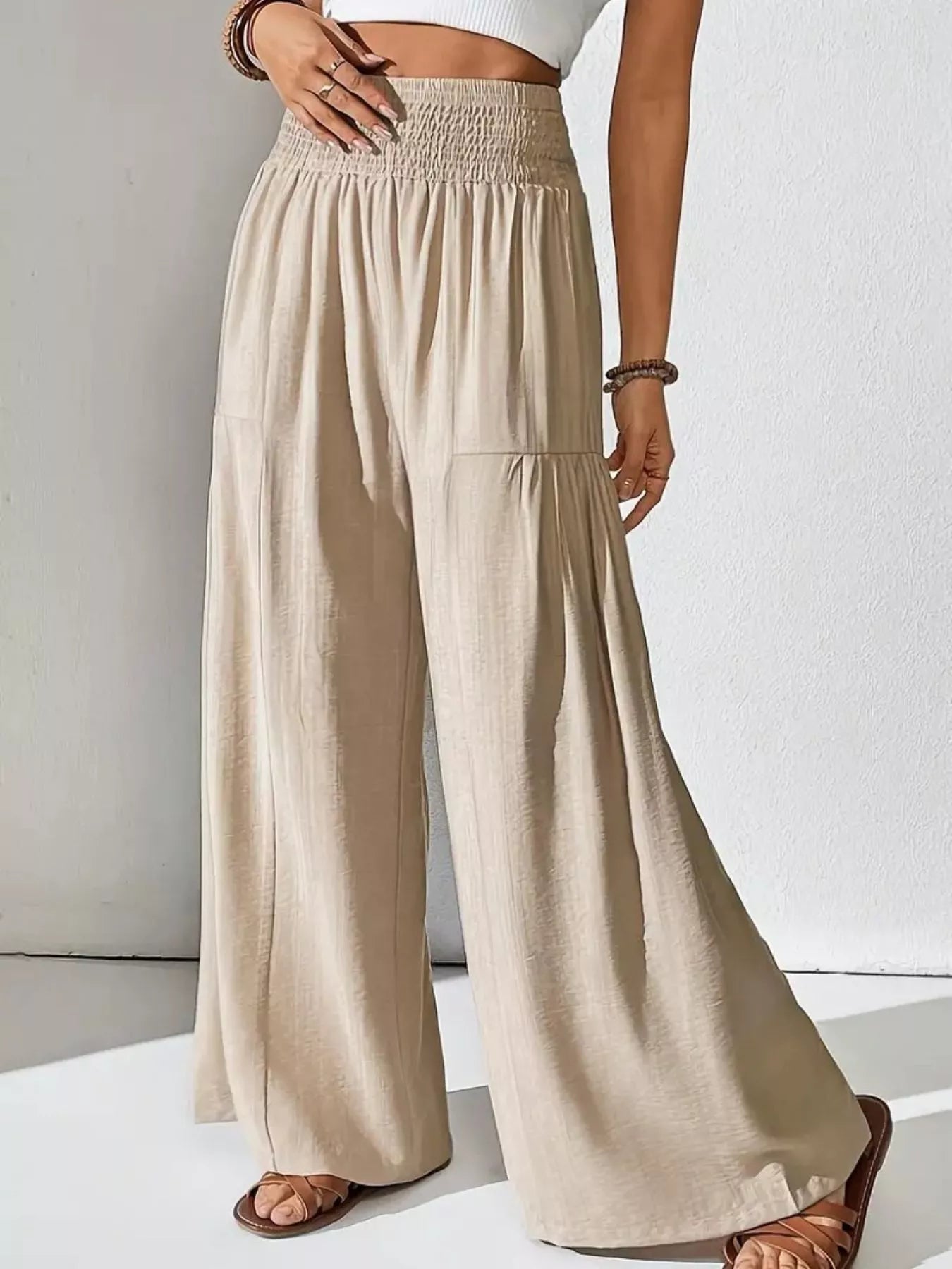 Beige wide-leg pants worn by a person on a white background