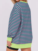 Person wearing a green and pink striped dress with a white background