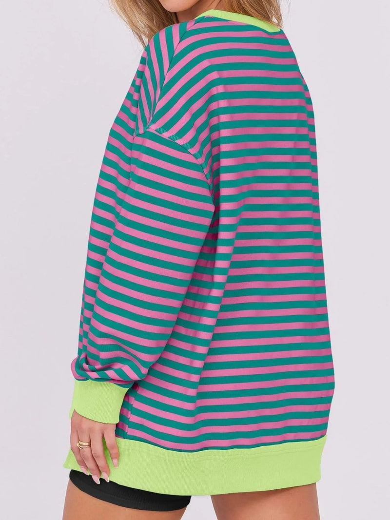 Person wearing a green and pink striped dress with a white background