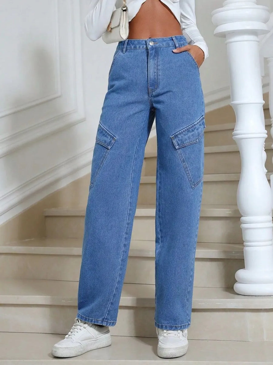 Person wearing blue jeans and white sneakers standing on a staircase.