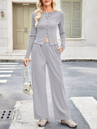 Woman wearing a gray outfit with wide-leg pants on a street.