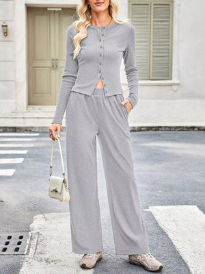 Woman wearing a gray outfit with wide-leg pants on a street.