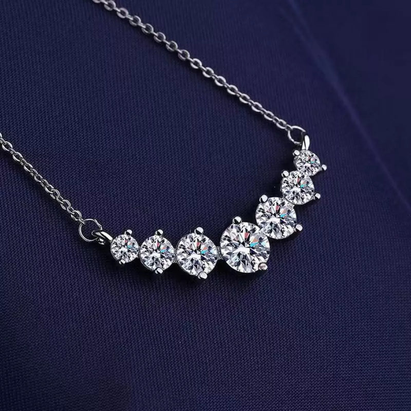Silver necklace with round crystals on a dark blue fabric background