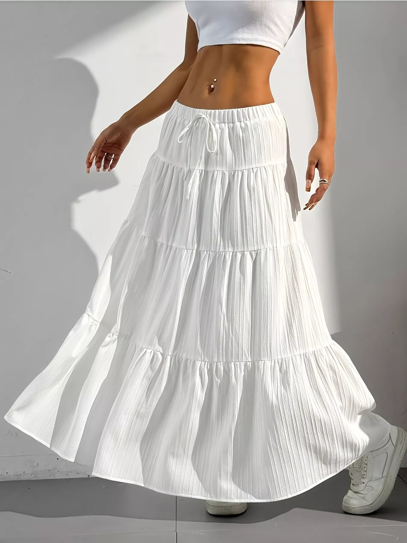 White tiered skirt worn by a person on a gray background