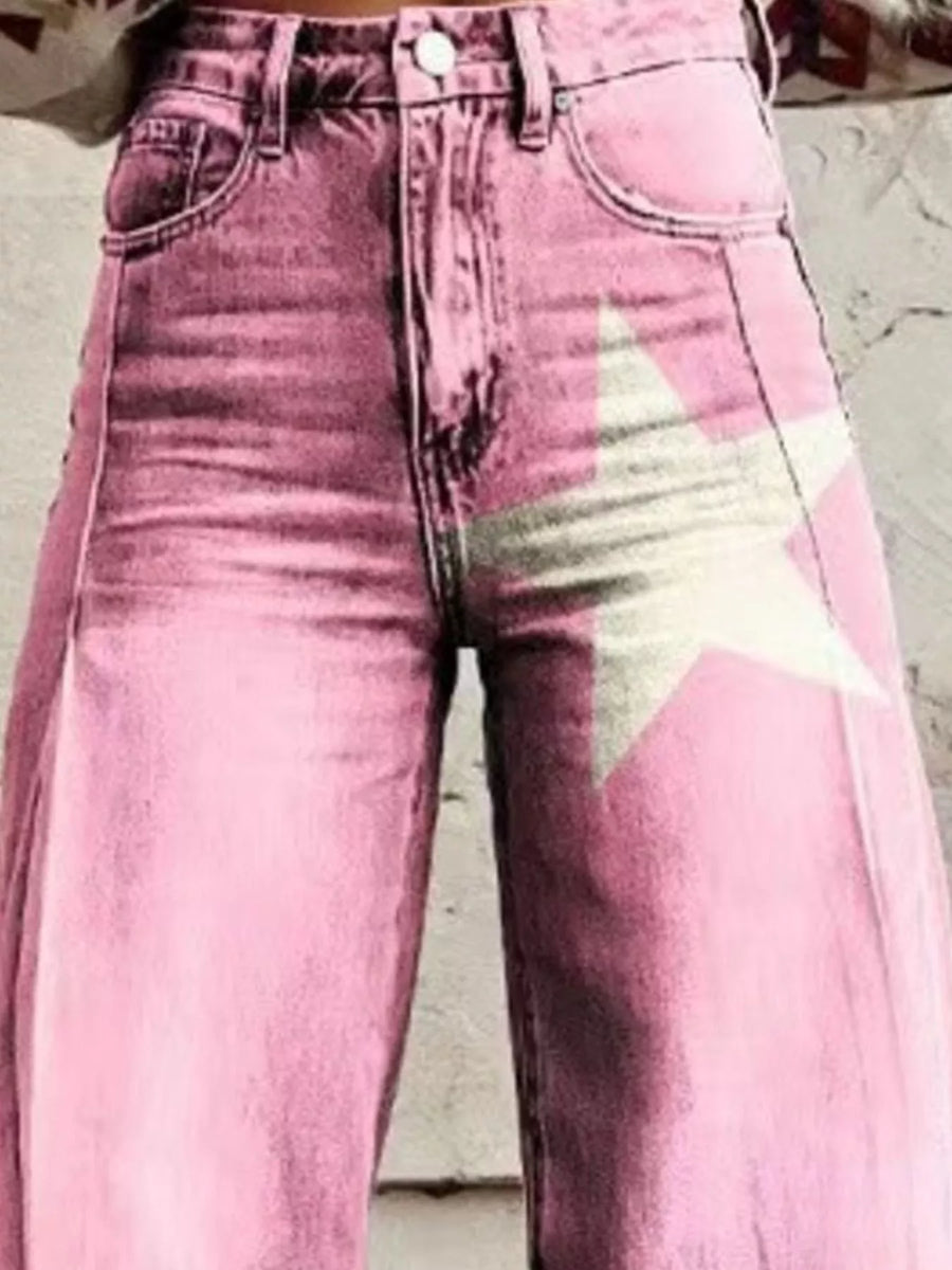 Pink acid-wash denim jeans with a large distressed white star graphic on the right leg, shown on a model.