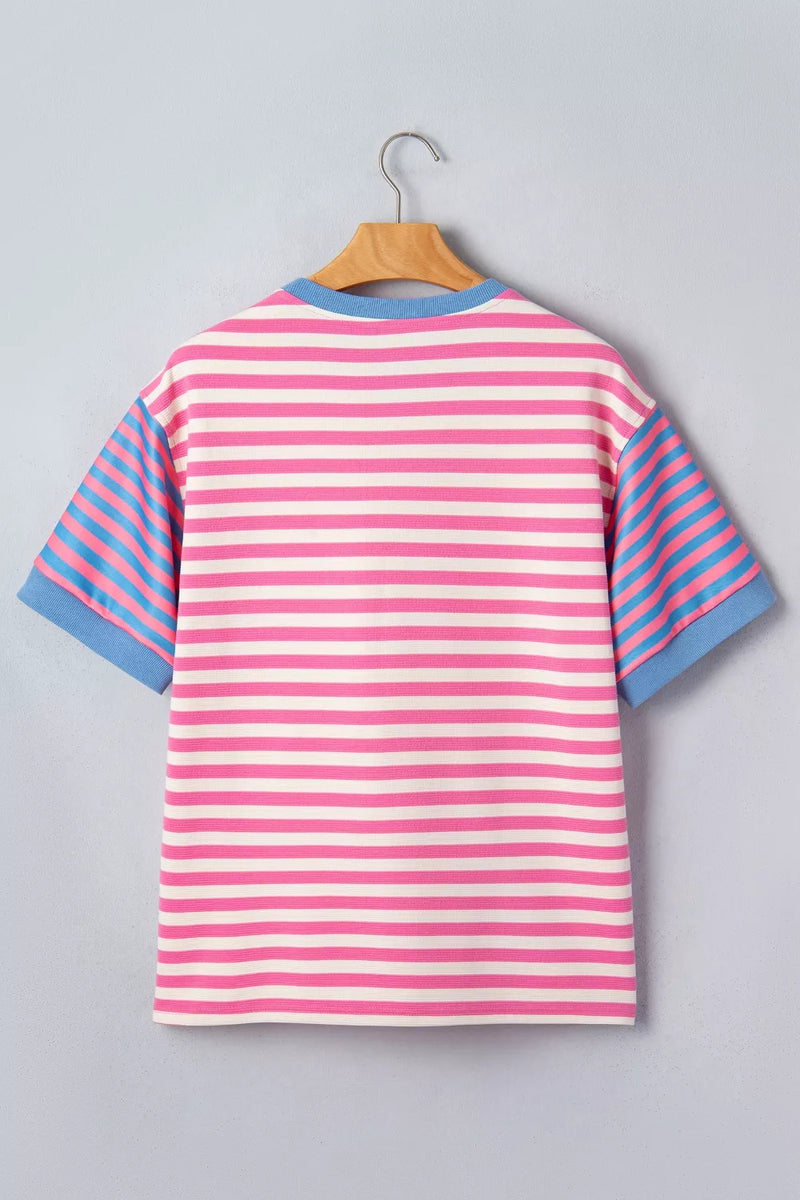 Pink and blue striped shirt on a hanger against a gray background