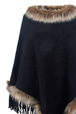Black poncho with fur trim on a white background