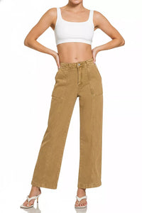 Woman wearing a white crop top and tan high-waisted pants on a white background