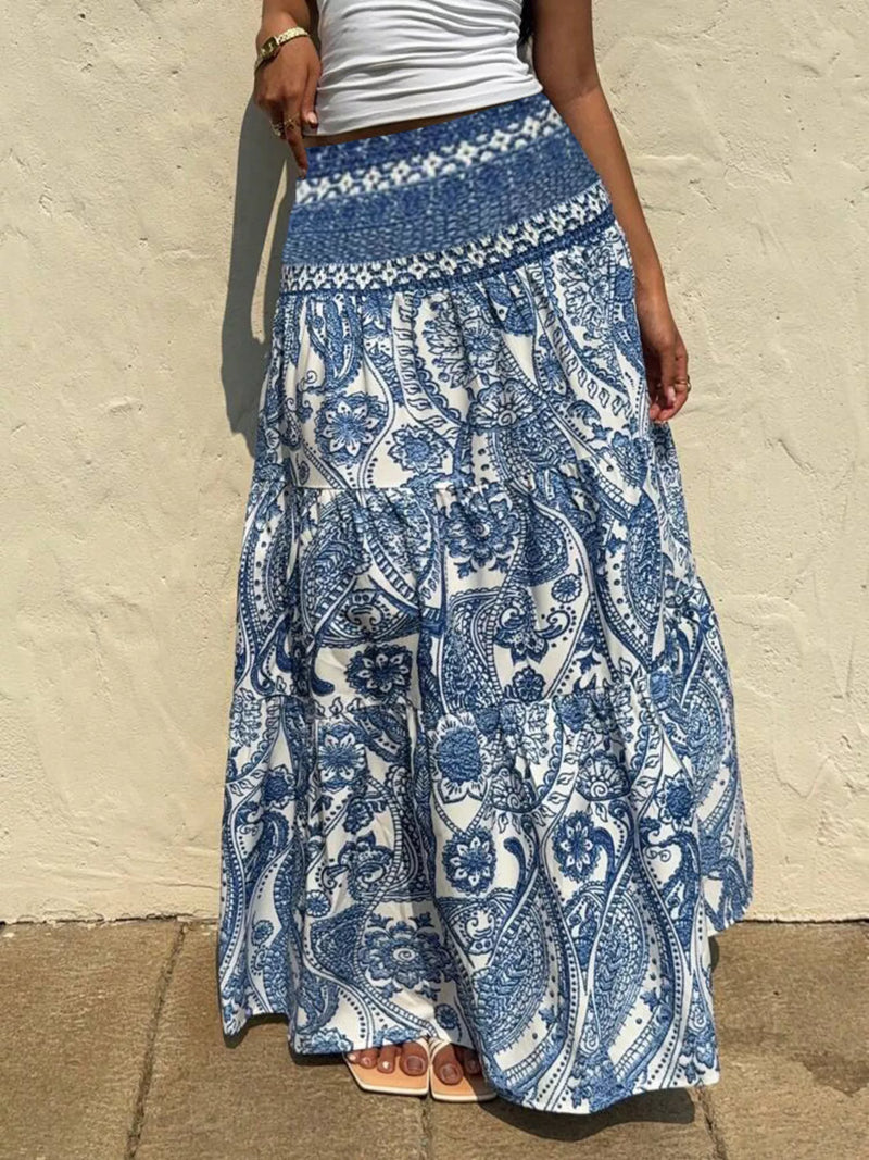 Person wearing a blue and white patterned skirt against a beige wall.