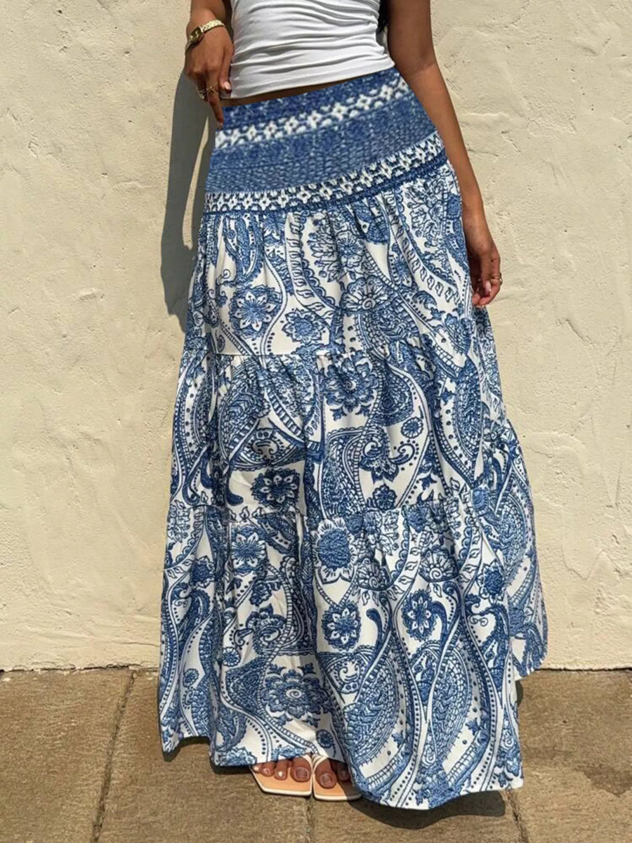 Person wearing a blue and white patterned skirt against a beige wall.