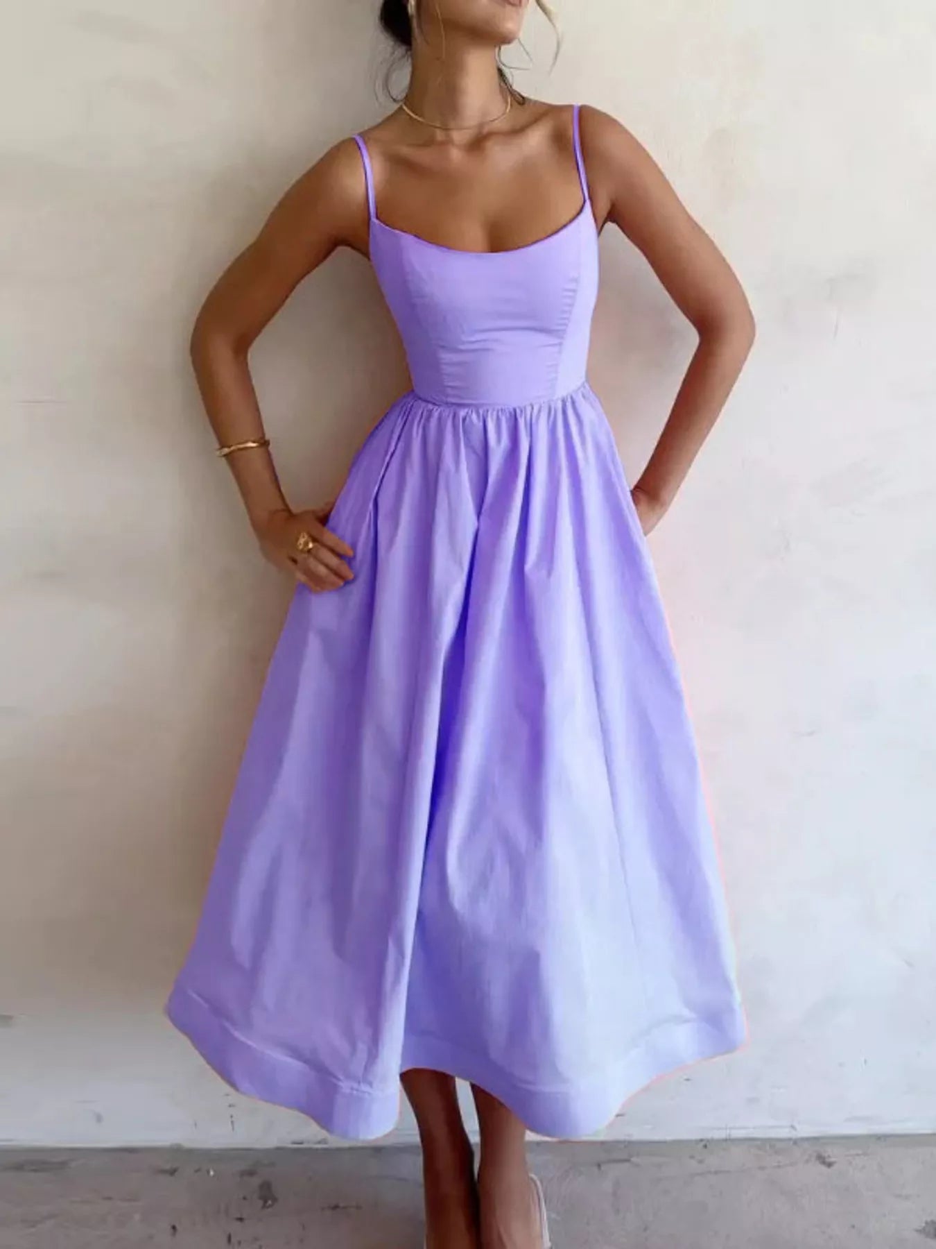 Woman wearing a light purple dress against a plain background