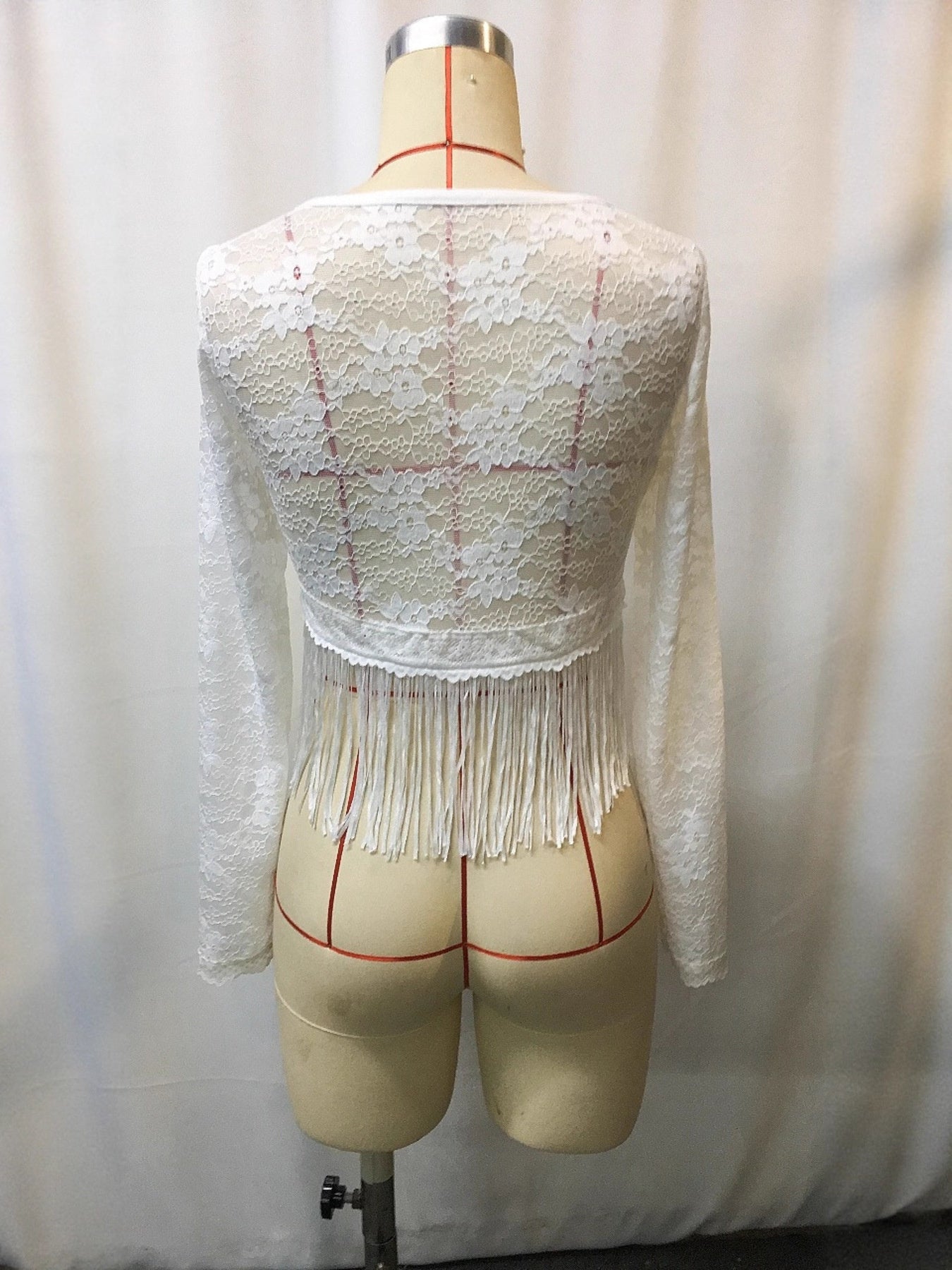 White lace top on a mannequin against a plain background