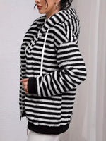 Black and white striped hoodie worn by a person on a plain background