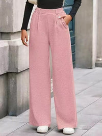 Person wearing pink wide-leg pants with a blurred background