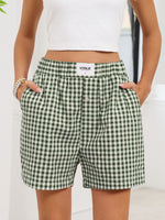Green and white checkered shorts with a visible brand logo on a plain background