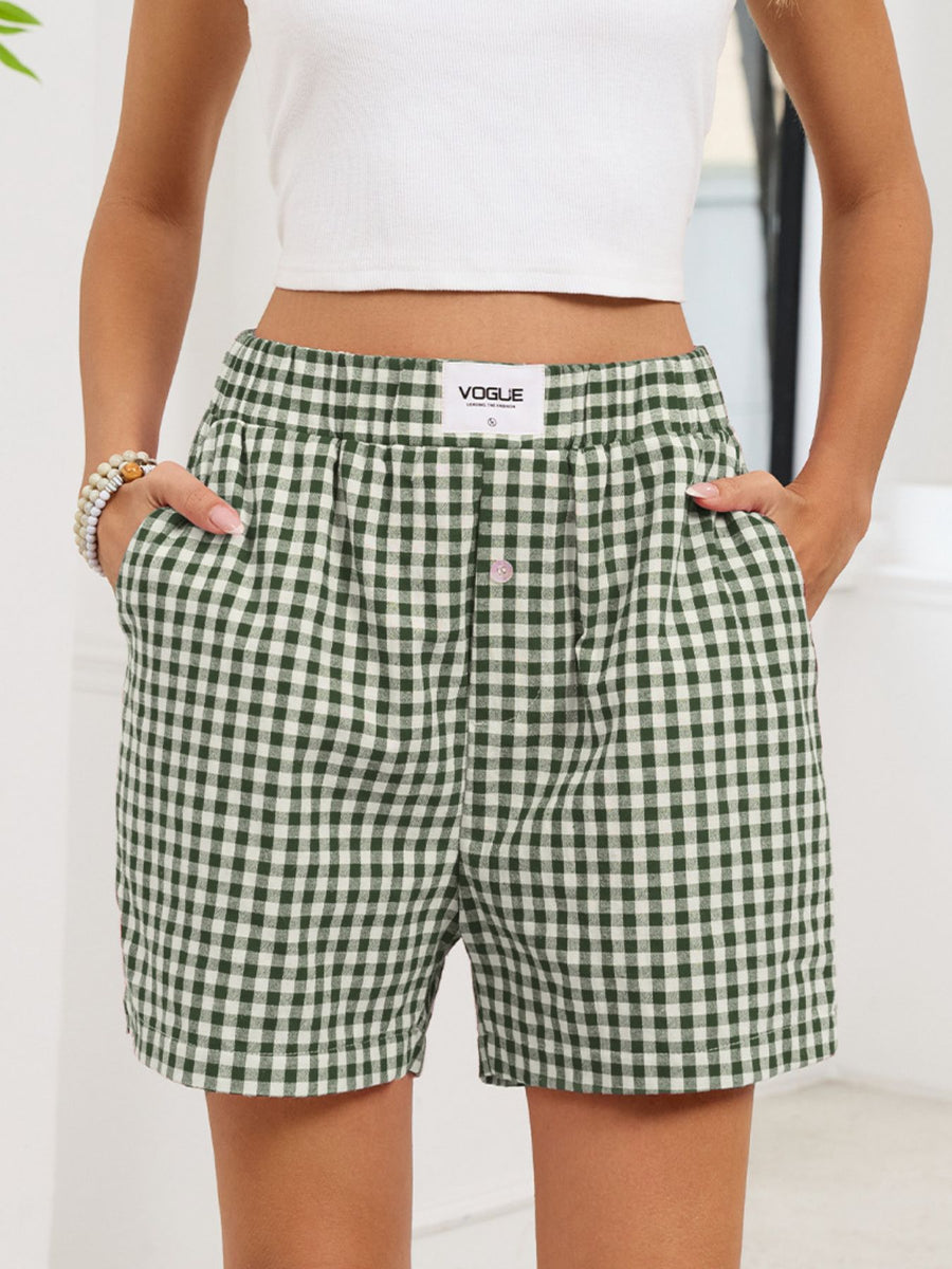 Green and white checkered shorts with a visible brand logo on a plain background