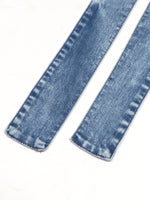 Close-up of blue denim jeans on a white background
