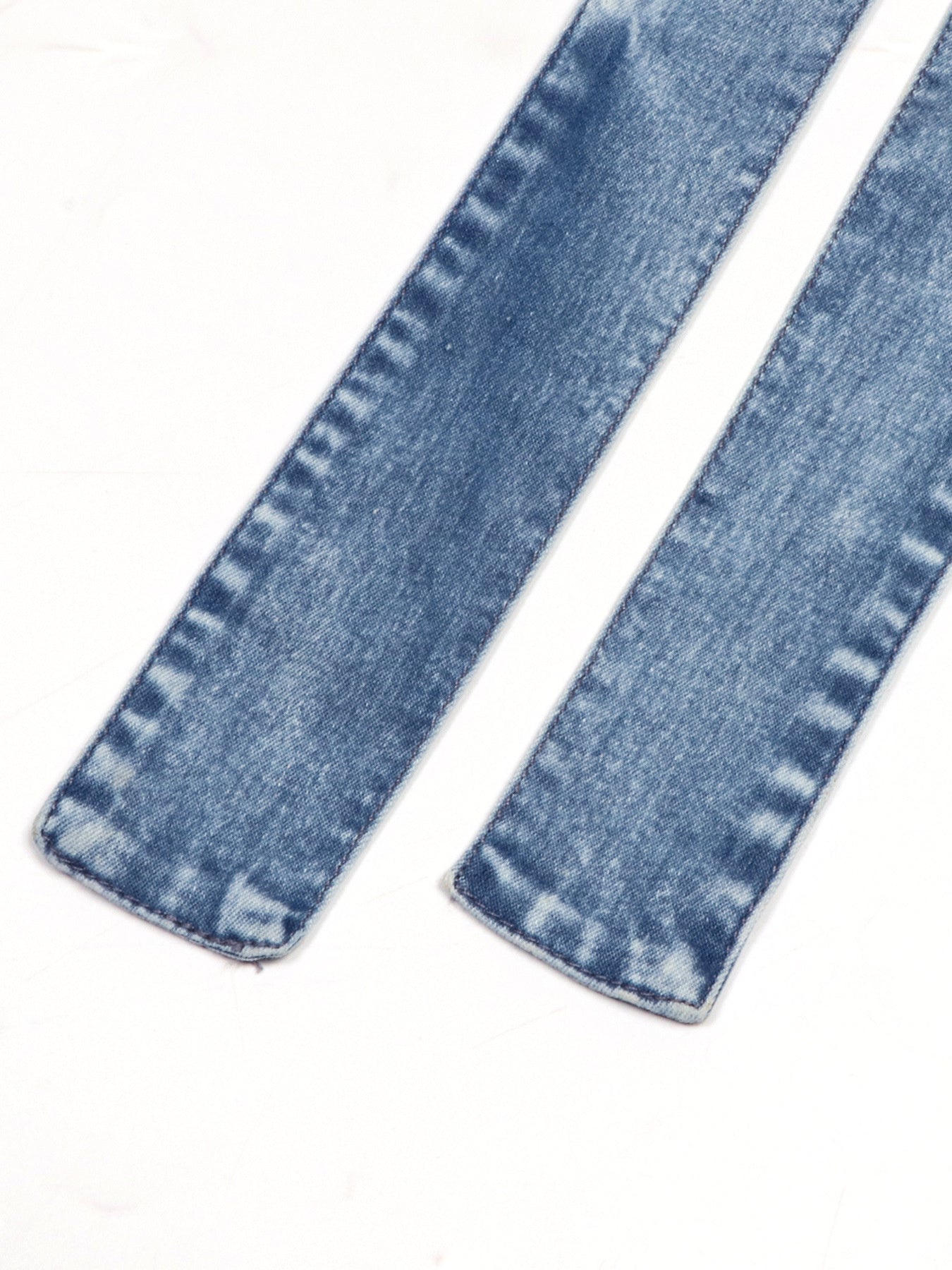 Close-up of blue denim jeans on a white background