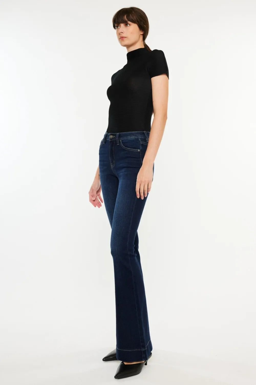 Person wearing a black turtleneck and dark blue jeans on a white background