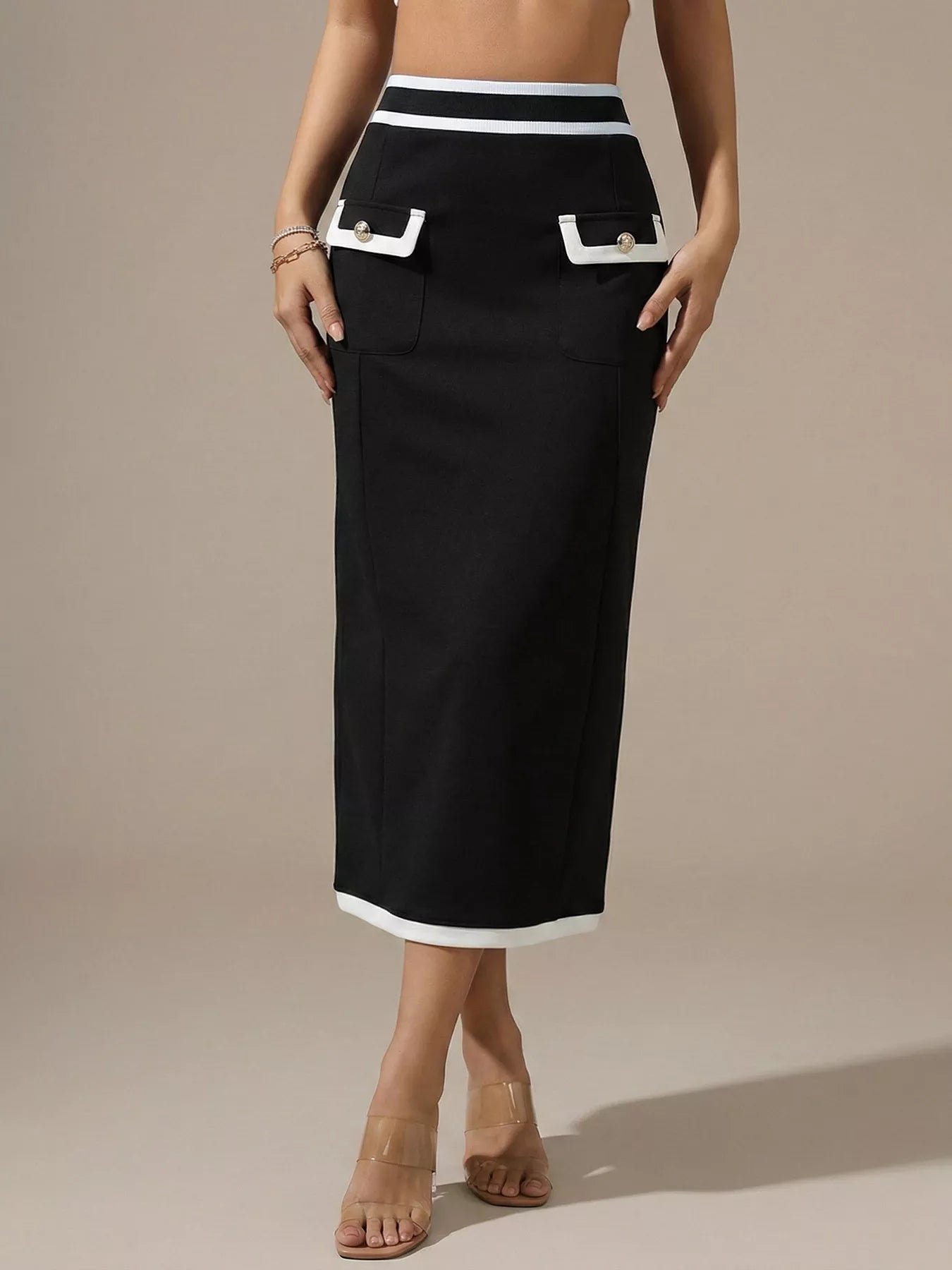 Black skirt with white trim worn by a person on a beige background