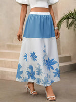 Woman wearing a blue and white floral skirt with a plain background