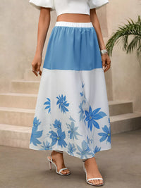 Woman wearing a blue and white floral skirt with a plain background