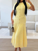Woman wearing a yellow dress in a modern living room.