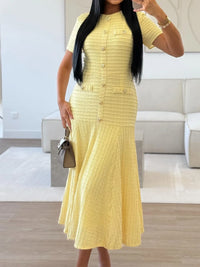 Woman wearing a yellow dress in a modern living room.