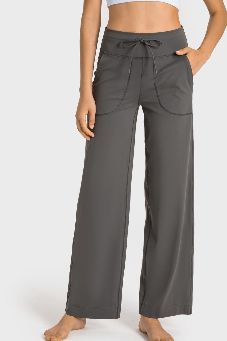 Person wearing gray wide-leg pants on a white background