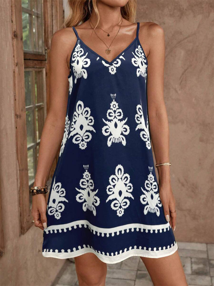 Navy blue dress with white patterns worn by a person, standing against a neutral background.