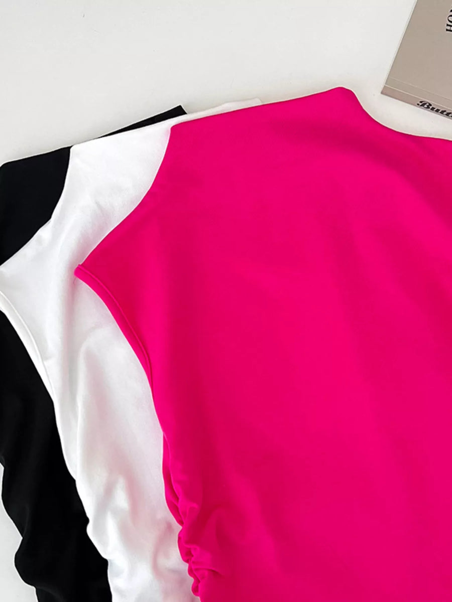 Close-up of a pink sleeveless top with white and black accents on a white background.
