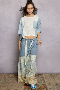Woman wearing a patchwork outfit with a plain background