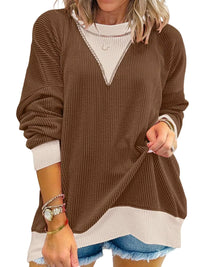 Brown sweater with white trim worn by a person on a white background