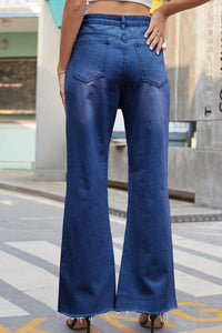 Person wearing blue flared jeans on a city street.