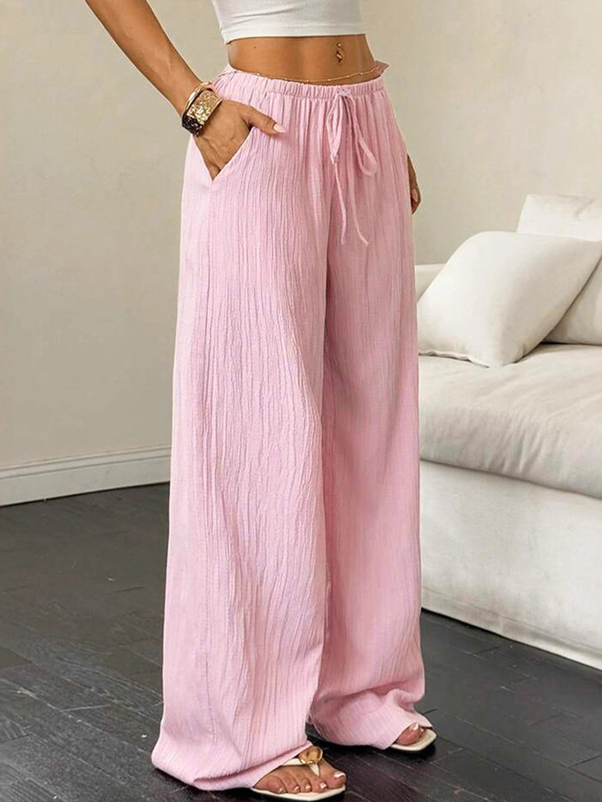 Person wearing pink wide-leg pants in a living room setting
