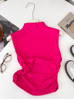 Pink sleeveless top on a hanger with a white background