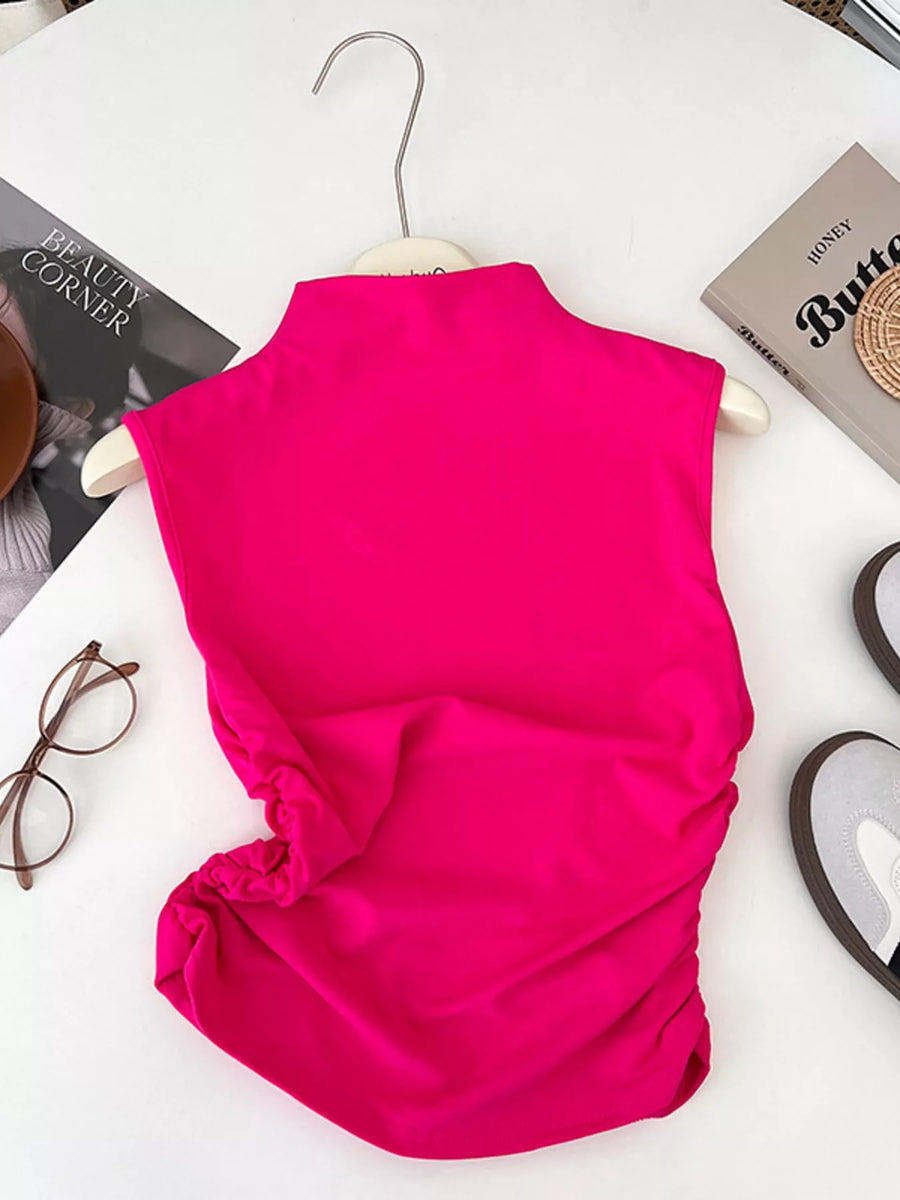 Pink sleeveless top on a hanger with a white background