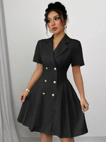 Woman wearing a black dress with gold buttons against a gray background