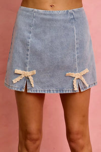 Denim skirt with bow details on a pink background