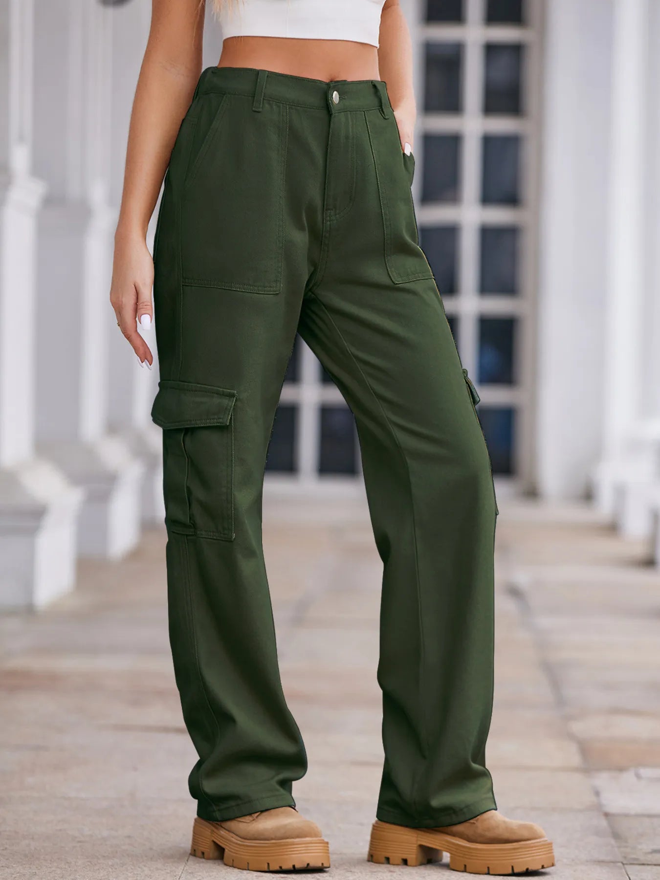 Person wearing green cargo pants standing on a wooden deck.