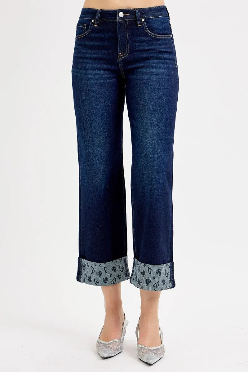 Dark blue jeans with patterned cuffs on a white background