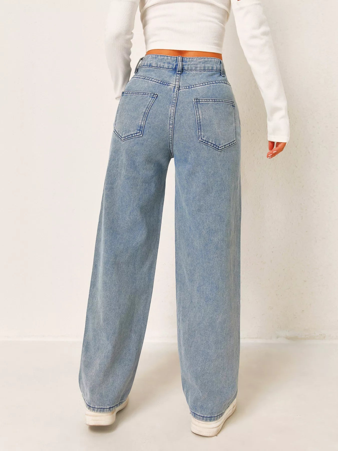 Light blue jeans worn by a person on a white background