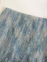 Close-up of a textured blue and gray rug on a white background